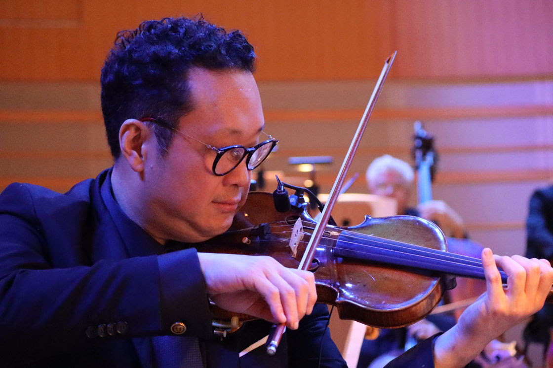 Dennis Kim playing the violin during a Pacific Symphony performance